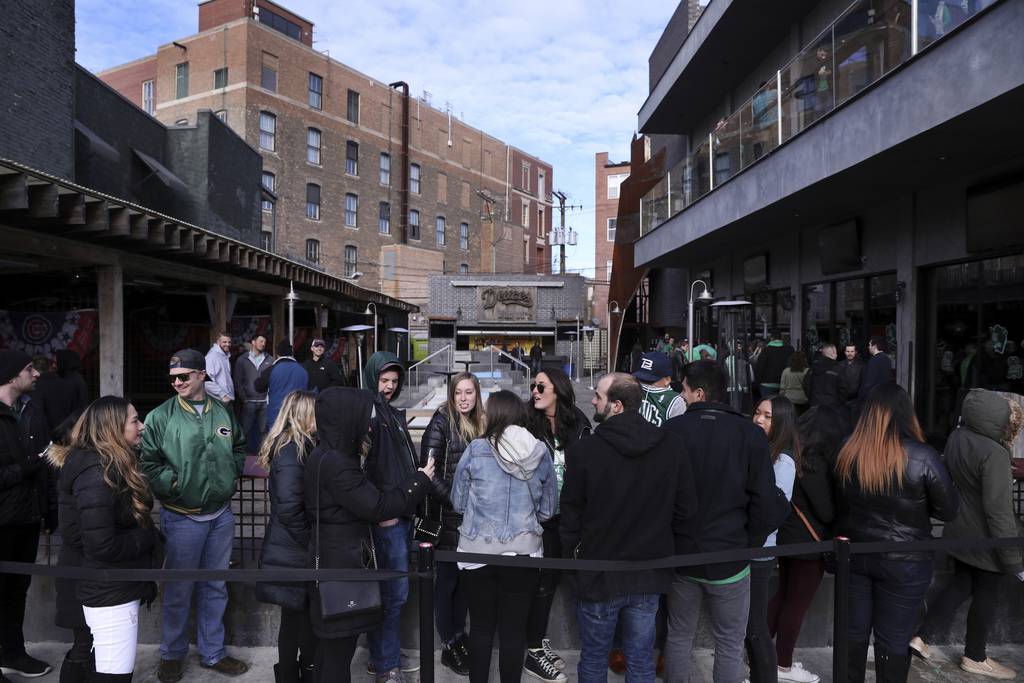 People wait to enter Deuce's and the Diamond Club on Clark Street while celebrating St. Patrick's Day in Chicago's Wrigleyville neighborhood on March 11, 2016.  