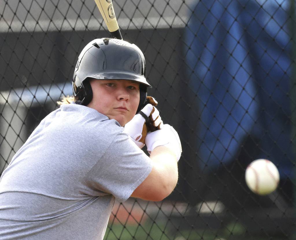 St. Charles East first baseman James Brennan eyes a pitch from a machine in the batting cage during practice in St. Charles on Thursday, March 23, 2023.