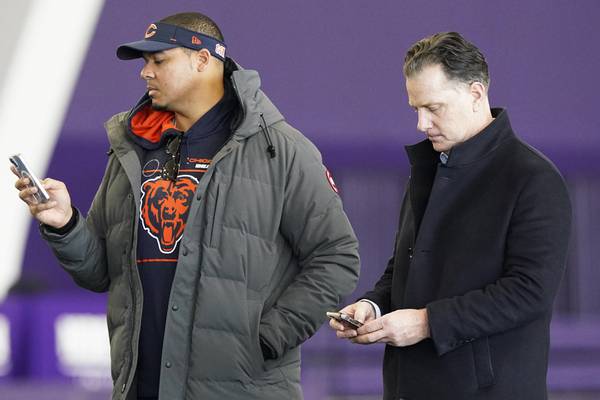 Bears general manager Ryan Poles, left, and coach Matt Eberflus look at their phone during Northwestern pro day on March 14, 2023.