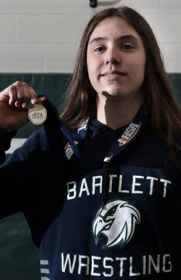 Bartlett High School sophomore Emma Engels, named IHSA state champion at the the Illinois High School Association girls wrestling finals, shyly displays her medal at school on March 23, 2023.