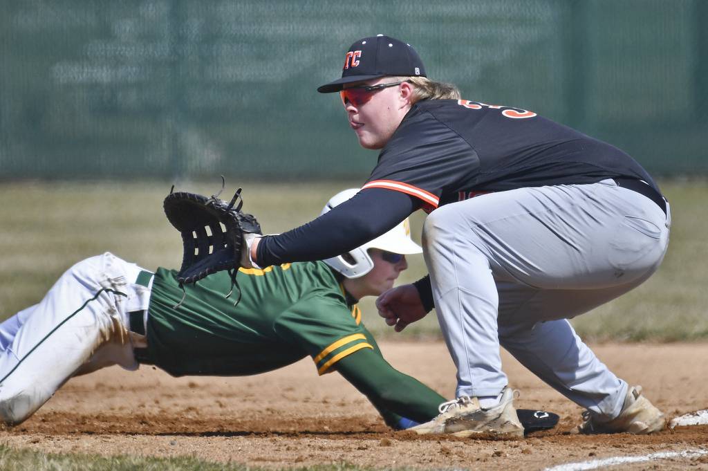 Waubonsie Valley's Ben Ford dives safely back as St. Charles East first baseman James Brennan waits for the throw during a nonconference game in Aurora on Monday, March 27, 2023.