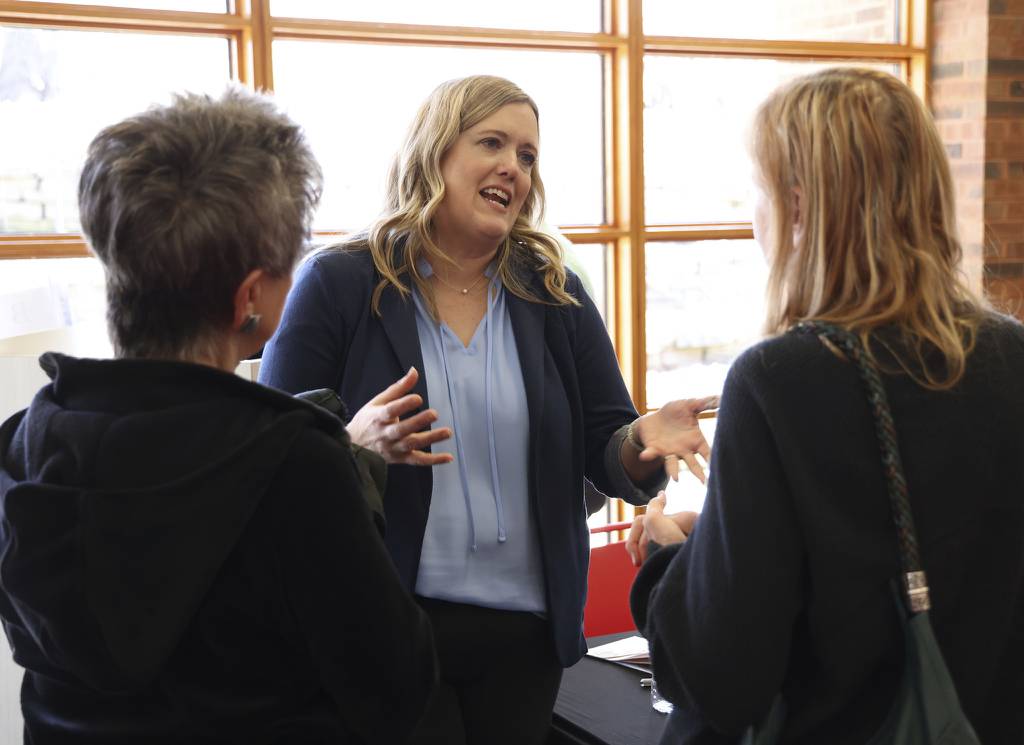 Katey Baldassano, center, speaks with community members following a candidate forum sponsored by the District 220 PTO Presidents’ Council at the Barrington Library on March 1, 2023. Baldassano is running for the school board in Barrington 220 School District and has teamed up with two other candidates, Matt Sheriff and Leonard Munson. 