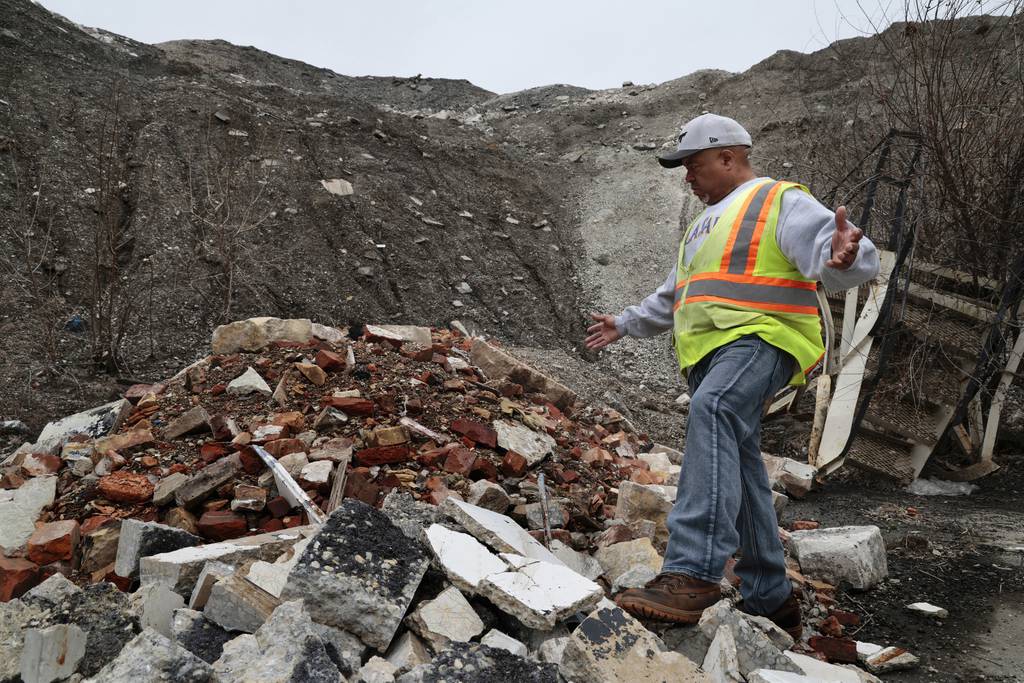 Bob Israel walks on a mound of debris along Normal Boulevard near 57th Street in Chicago, March 16, 2023. Norfolk Southern has been pursuing its $150 million plan to double the size of its intermodal freight yard at 47th Street and the Dan Ryan.