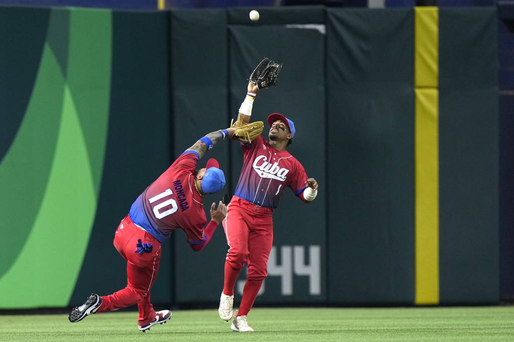 Cuba third baseman Yoán Moncada, left, and outfielder Roel Santos collide while chasing a fly ball during a World Baseball Classic semifinal against the Uniited States on Sunday in Miami. 