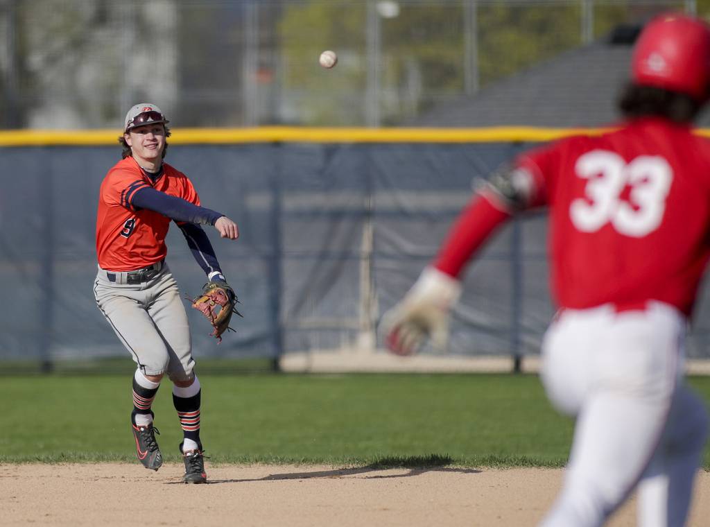 Naperville North’s Tanner Mally (9) throws to first base to force out Naperville Central’s Michael Umbright (33) during a DuPage Valley Conference game in Naperville on Tuesday, April 26, 2022.