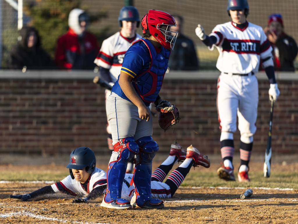 St. Rita’s MJ McKinney dives into home plate with the go-ahead run against De La Salle during a Catholic League crossover in Chicago on Tuesday, March 28, 2023.