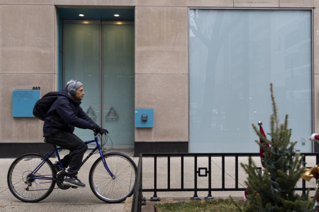 A bicyclist passes a vacant storefront along Chicago's Michigan Avenue on Nov. 15, 2022. Real estate firm CBRE reported the vacancy rate among downtown office buildings ended last year at an all-time high.