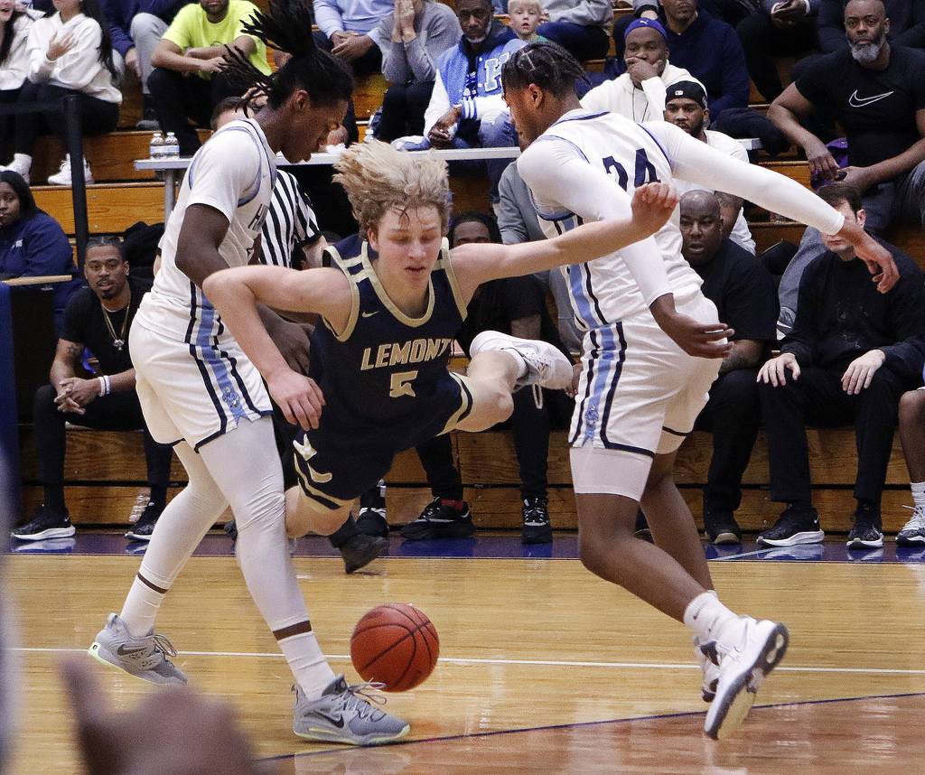 Lemont's Rokas Castillo dives after the ball between Hillcrest's Quentin Heady (5) and Darrion Baker (24) during the Class 3A Hillcrest Sectional championship game in Country Club Hills on Friday, March 3, 2023.