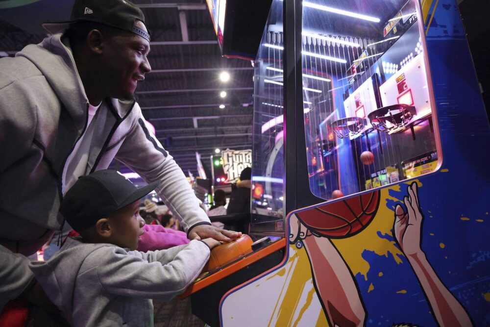Former Simeon basketball player Kendall Pollard spends time with his son, Kyaire, at a gaming arcade in Orland Park on Feb. 3, 2023. 