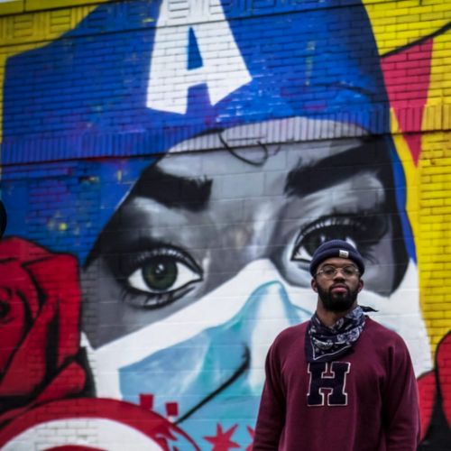 Dwight White II standing in front of his old murals in Chicago's Medical District