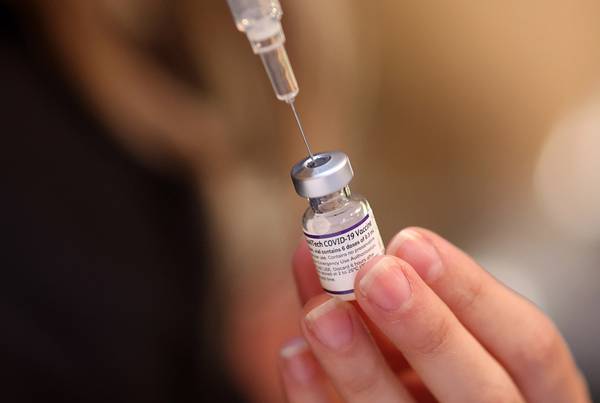 A Roseland Community Hospital nurse prepares doses of the Pfizer vaccine on Dec. 30, 2021, during a COVID-19 vaccination event.