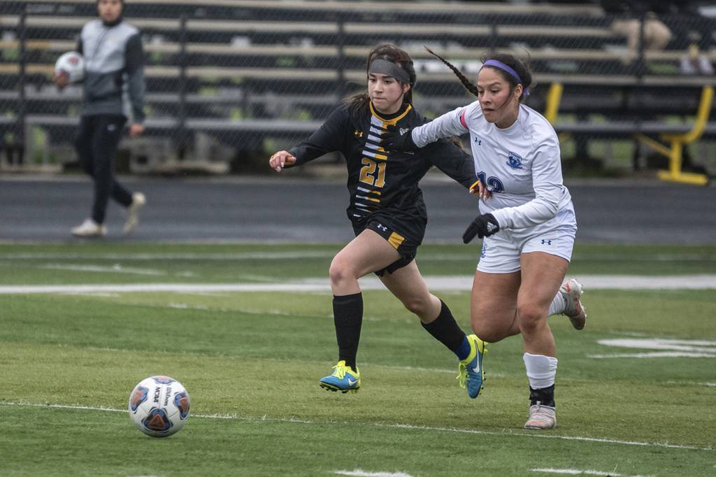 Marian Catholic’s Gianna Arriaga (21) and Bloom’s Charlene Mendoza (12) attack the ball during a nonconference game in Chicago Heights on Friday, May 6, 2022.