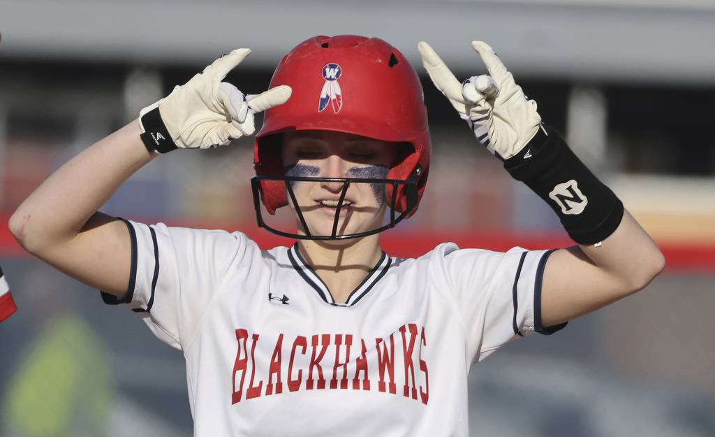 West Aurora's Katelyn Serafin (14) reacts to cheers from teammates after driving in a run with a double against Yorkville during a Southwest Prairie Conference game on Thursday, April 13, 2023.