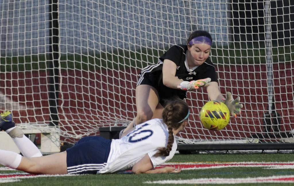 Naperville Central goalkeeper Erin Hackett, top, makes a save against Neuqua Valley’s Alexis May during a DuPage Valley Conference game in Naperville on Tuesday, April 11, 2023.
