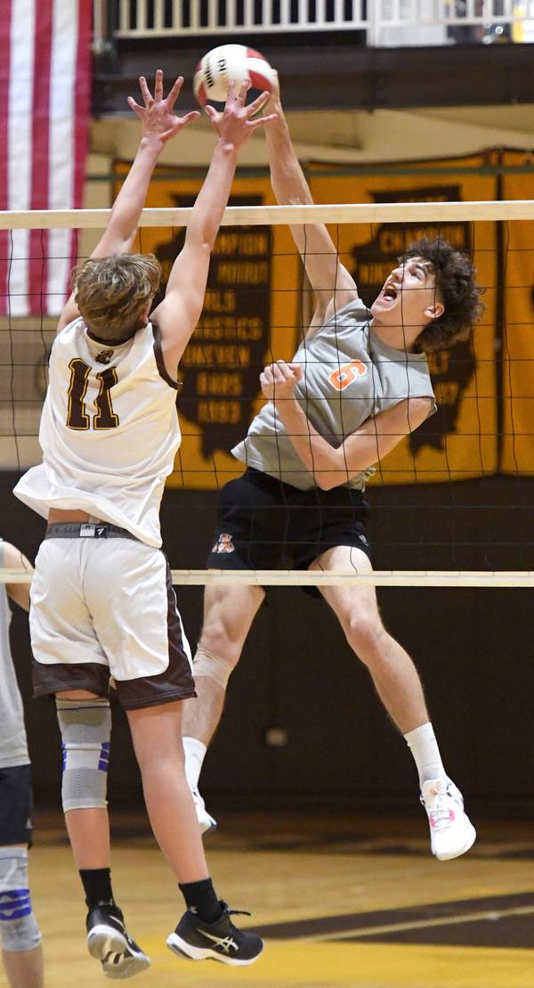 Libertyville’s Aleks Slesers (6) spikes the ball against Carmel’s Xander Ikusz during a match in Mundelein on Tuesday, April 4, 2023. 
