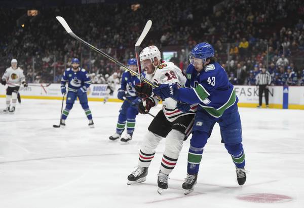 The Canucks' Quinn Hughes checks the Blackhawks' Jonathan Toews during the first period on April 6, 2023.
