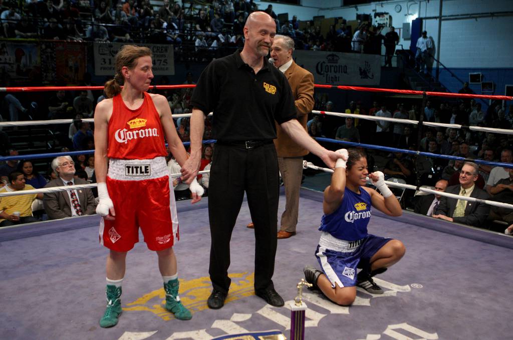 Kerstin Broockman, red trunks, looks on as Tiffany Perez reacts following the announcement of the winner during the Chicago Golden Gloves championship fights at St. Andrew's gym in Chicago, April 10, 2010.  