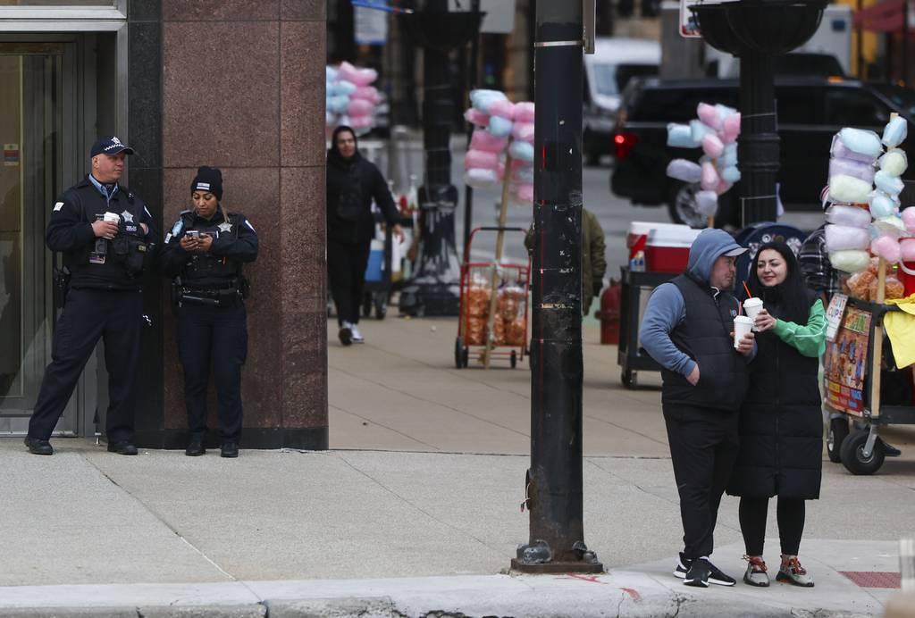 Chicago police officers stand at the corner of Washington Street and Michigan Avenue on April 23, 2023. 