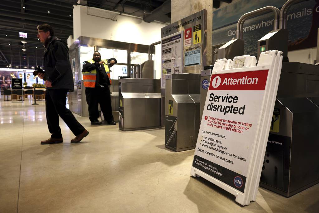 With a sign reading “service disrupted,” a passenger is directed away from the Merchandise Mart CTA station after a track power outage shut part of the CTA’s system on March 14, 2023. 