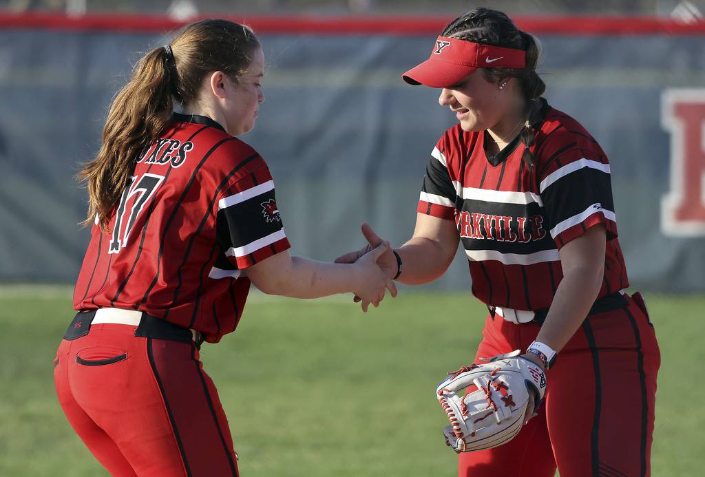 Yorkville third baseman Abby Pool (17) and shortstop Sara Ebner celebrate an out against West Aurora during a Southwest Prairie Conference game on Thursday, April 13, 2023.