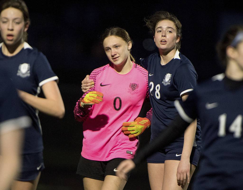 Bartlett's Megan Kron (0) is consoled by team captain Brooke Baumann (28) at halftime against Geneva during a nonconference game in Bartlett on Monday, April 3, 2023.