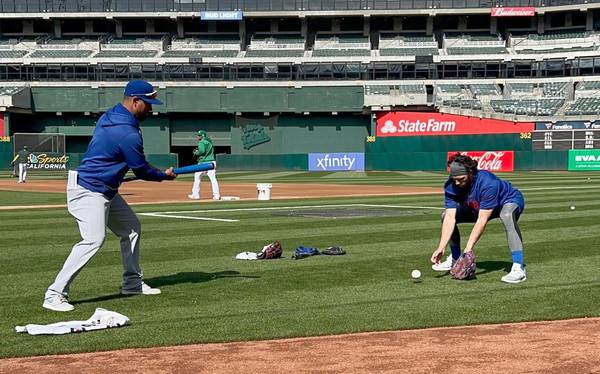 Cubs shortstop Dansby Swanson practices defensive drills with Jonathan Mota before a game in Oakland, Calif., on April 17, 2023.