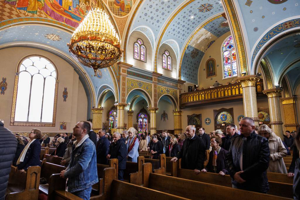 People stand while attending a Palm Sunday service at St. Nicholas Ukrainian Catholic Cathedral in Chicago on April 2, 2023.