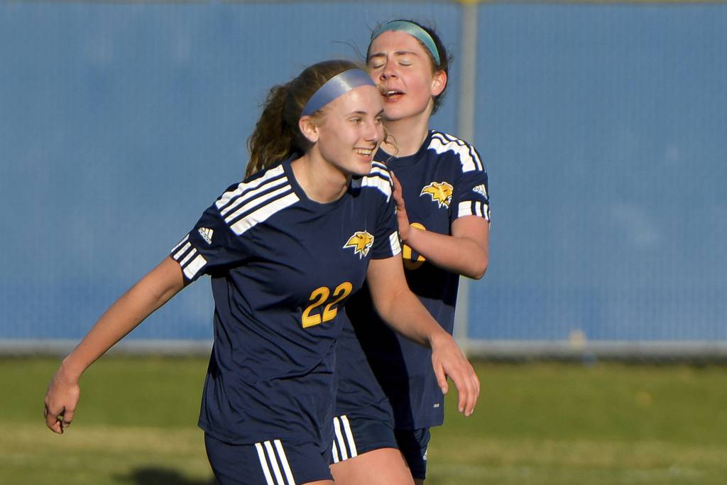 Neuqua Valley’s Brianna Clasen (22) is congratulated by teammate Alexis May after scoring a goal against Downers Grove North during a game in Naperville on Thursday, April 6, 2023. 