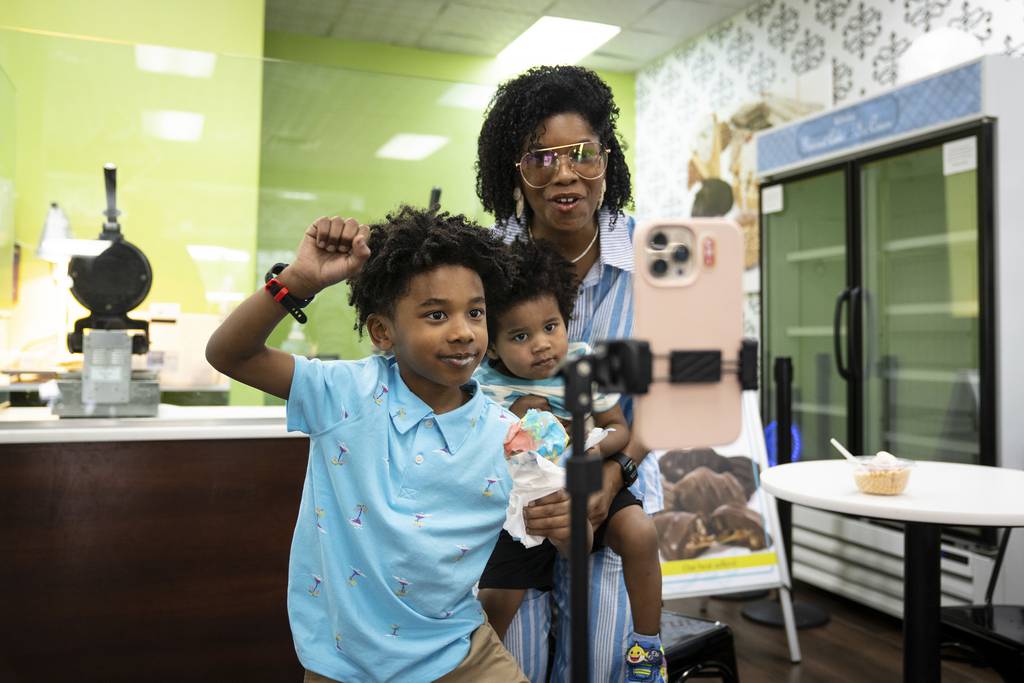 Vlogger Jenny LeFlore, her sons Obie Q. LeFlore, 6, and Jameson LeFlore, 2, record an Instagram reel at an ice cream shop in Hyde Park on April 13, 2023.  