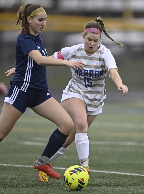 Warren’s Paige Hogberg (15) challenges Glenbrook South’s Meghan Noe during a game in Glenview on Monday, April 3, 2023.