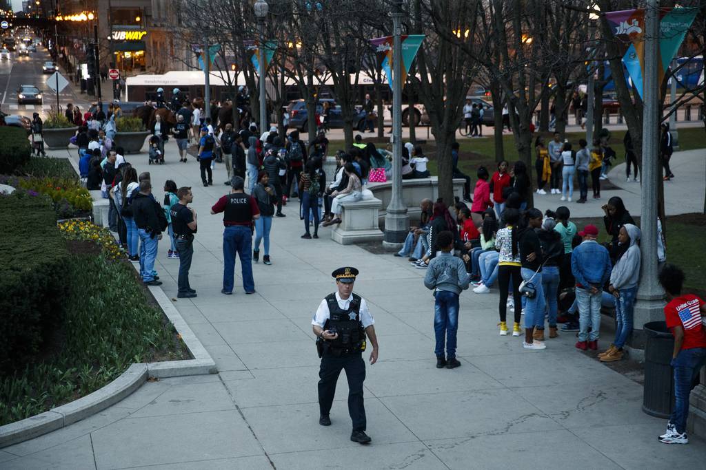 Police monitor a group of teens and young adults in Millennium Park after several fights occurred on April 17, 2019, in Chicago. 