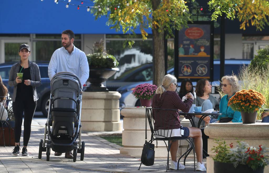 Customers sit outdoors in the Arlington Alfresco outdooring dining venue, indulging in conversation and food, in downtown Arlington Heights Sept. 29, 2021. 