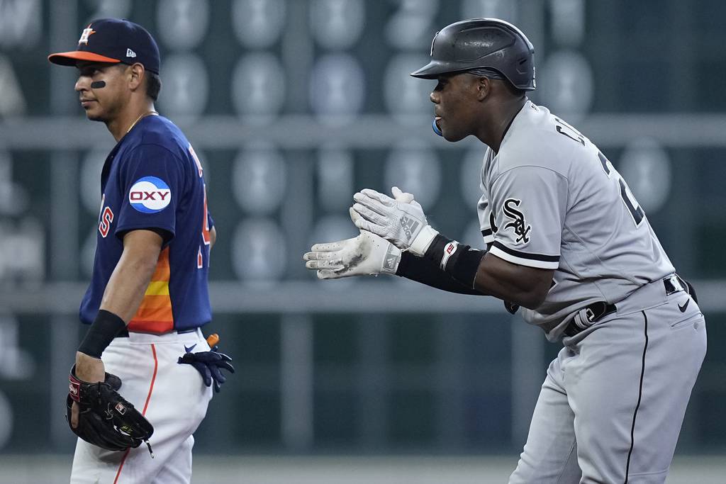 White Sox outfielder Oscar Colás, right, celebrates behind Astros second baseman Mauricio Dubon after hitting an RBI double during the sixth inning Sunday, April 2, 2023, in Houston.