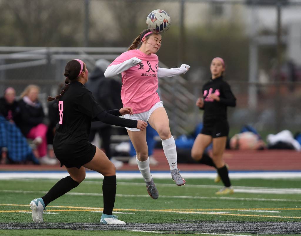Lincoln-Way West's Kylie Murphy (22) heads the ball past Lincoln-Way East's Thea Gerfen (8) during a  SouthWest Suburban Conference crossover in Frankfort on Monday, April 17, 2023.