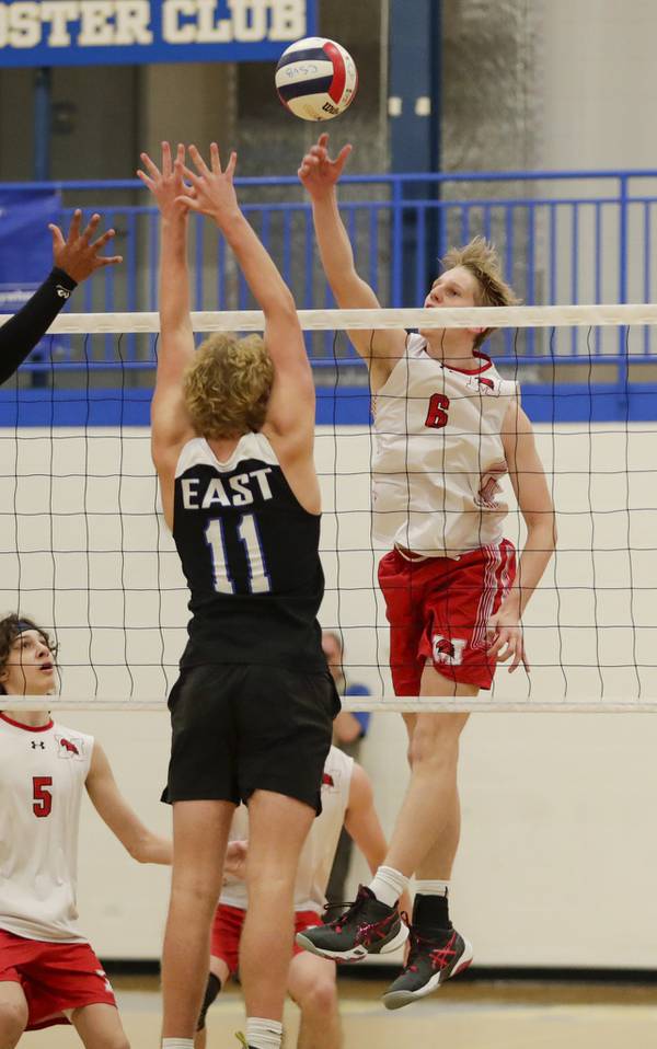 Marist’s Alex Smith (6) goes up for a kill against Lincoln-Way East’s Jordan Hicks (11) during the Sandburg Sectional championship match in Orland Park on Tuesday, May 31, 2022.