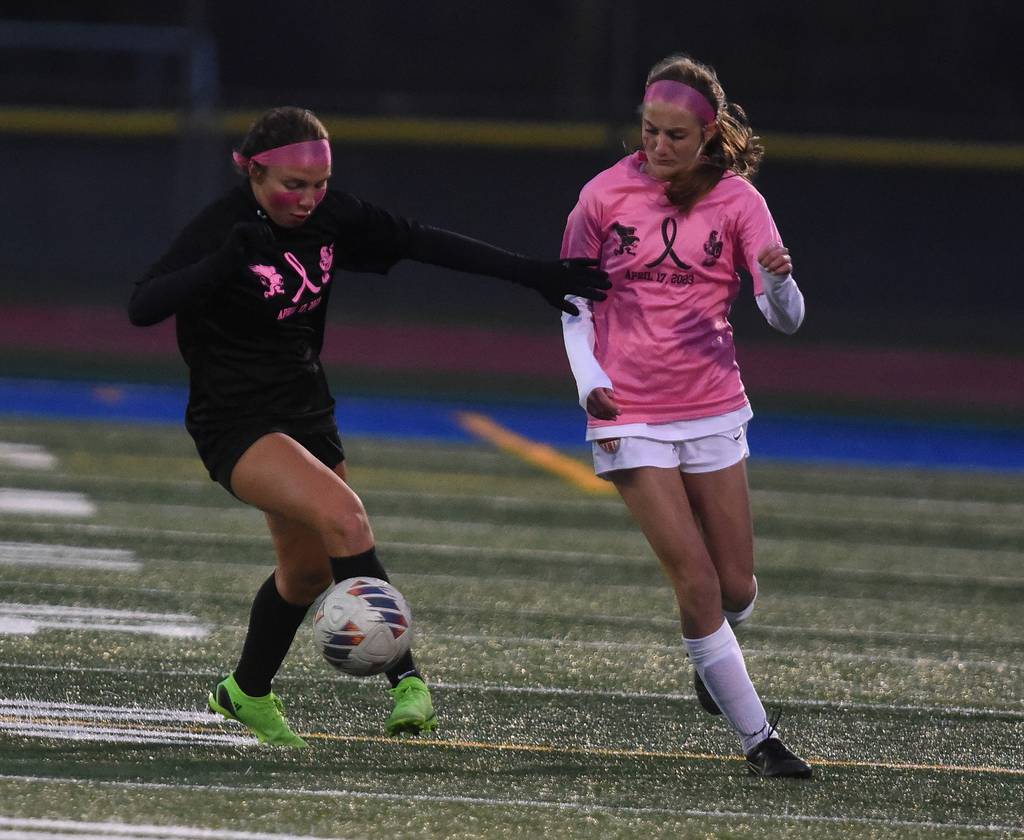 Lincoln-Way East's Madison Dziedzic (21) works the ball up the field against Lincoln-Way West's Ava Bach (9) during a SouthWest Suburban Conference crossover in Frankfort on Monday, April 17, 2023.