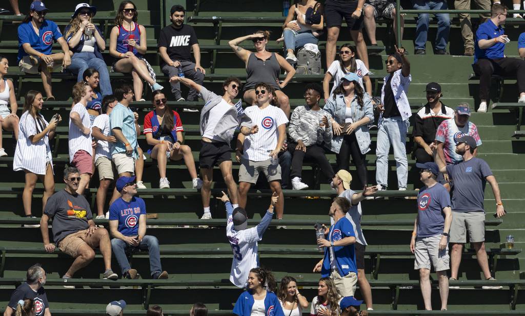 A bleacher fan throws back a home run by the Mariners' Jarred Kelenic in the eighth inning on April 12, 2023, at Wrigley Field.