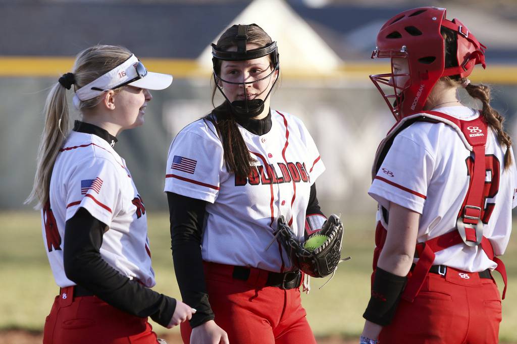 Grant teammates Gigi Bendinelli, from left, Shelby Wasilewski and Tara Levernier get together for a quick chat during the final inning of a game against Grayslake Central in Grayslake on Thursday, April 6, 2023. 
