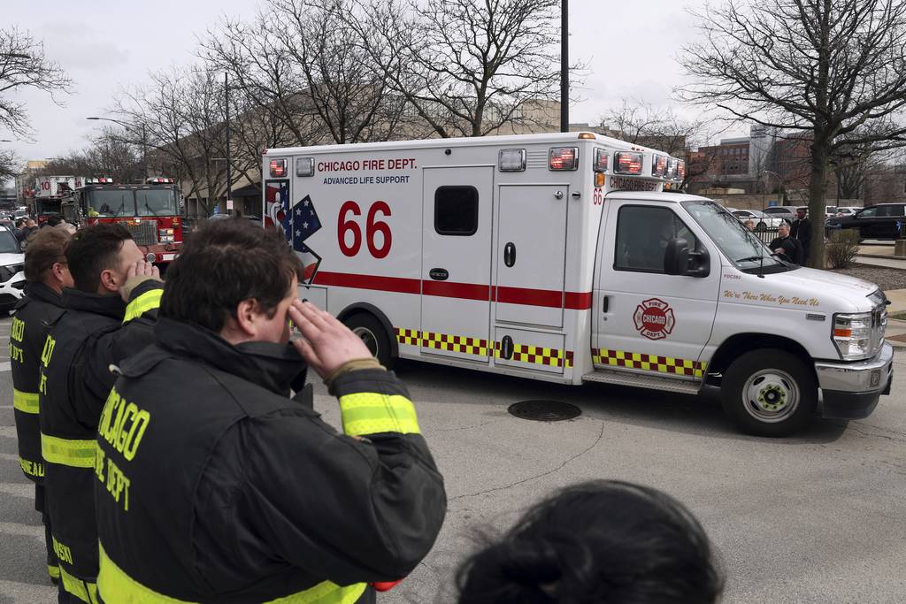 Chicago firefighters salute as the body of Chicago Fire Department Lt. Jan Tchoryk arrives at the Cook County Medical Examiner's Office in Chicago on April 5, 2023. 
