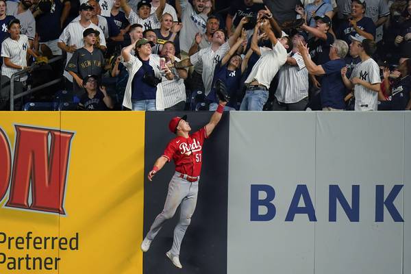 The Reds' Stuart Fairchild chases a ball hit by the Yankees' Giancarlo Stanton for a home run during the eighth inning of a game on July 13, 2022.