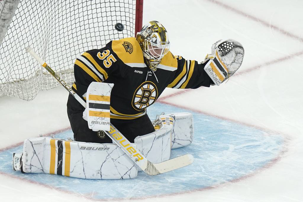 Boston Bruins goaltender Linus Ullmark (35) deflects the puck while warming up before an NHL hockey game against the Columbus Blue Jackets, Thursday, March 30, 2023, in Boston. (AP Photo/Steven Senne)