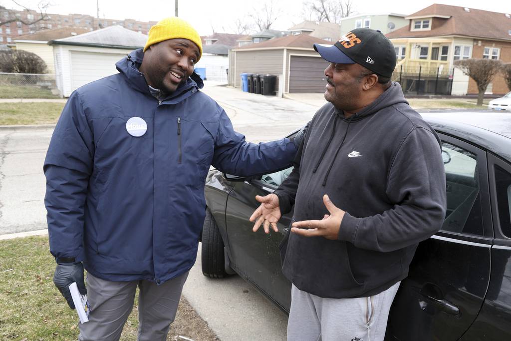 Chicago aldermanic candidate Ronnie Mosley, left, talks to resident Marlon Ashby while canvassing in the 21st Ward on March 22, 2023. 