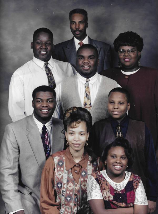 Taken in 1995, the year mother Wilma Jean Johnson died at age 50, a photo shows Brandon Johnson surrounded by family. Clockwise from top center are: Dad Rev. Andrew Johnson and siblings Andrea, Aaron, Ashley, Joy, Jeremy and cousin Jamie, who lived with the family at the time. 