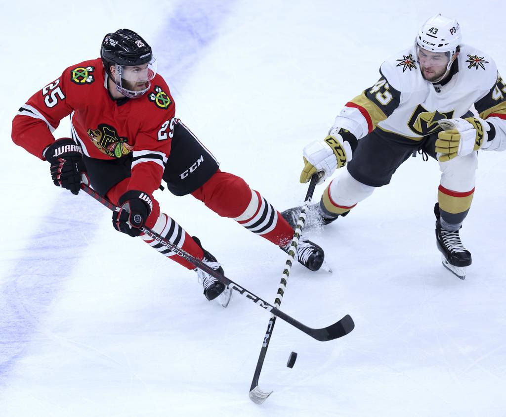 Blackhawks defenseman Jarred Tinordi (25) and Golden Knights center Paul Cotter battle in the second period on Dec. 15, 2022, at the United Center. 