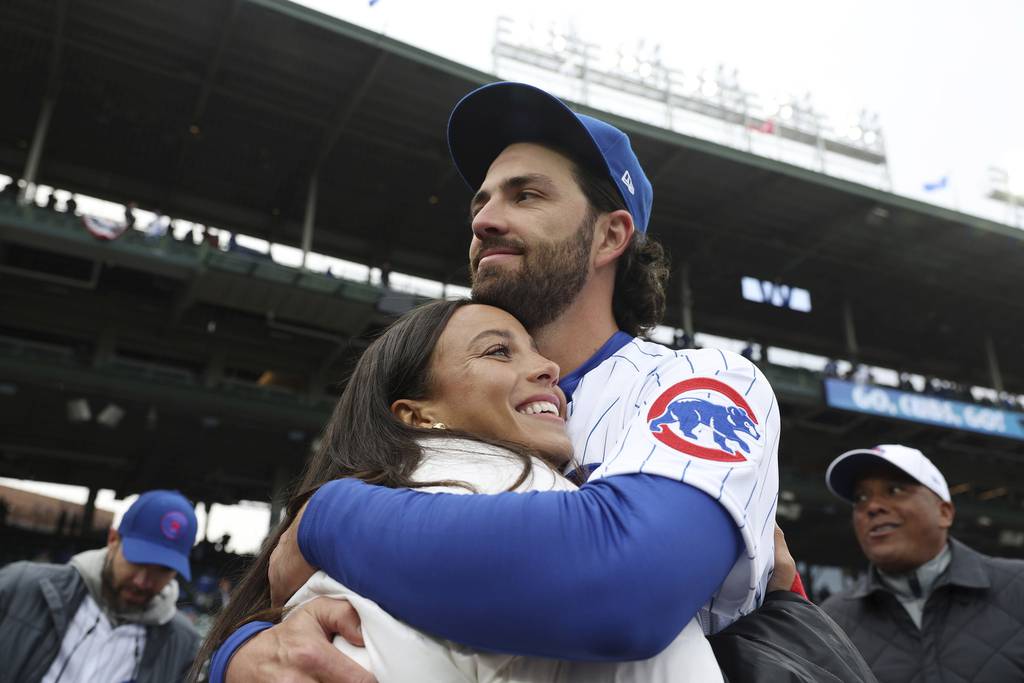 Cubs shortstop Dansby Swanson hugs his wife, Red Stars forward Mallory Swanson, on opening day at Wrigley Field on March 30, 2023.