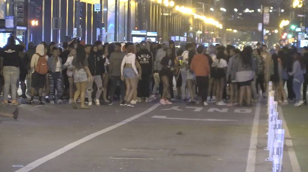 A large group of young adults and juveniles congregate in the streets of downtown Chicago Saturday night.