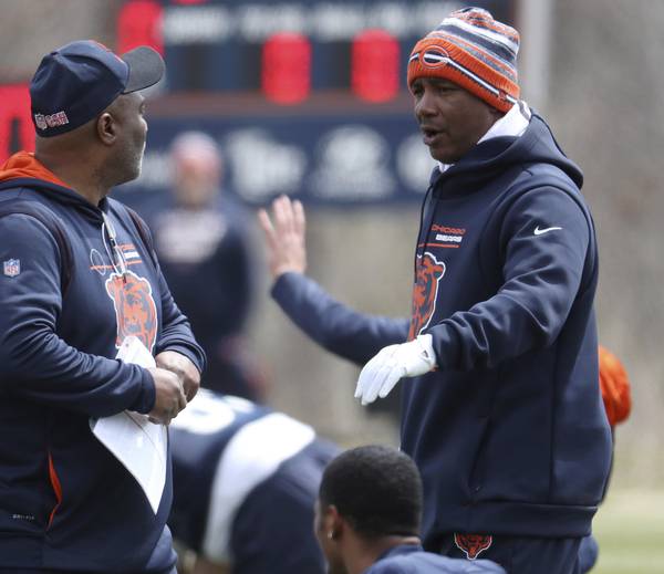 Bears wide receivers coach Tyke Tolbert, right, walks the field during minicamp on April 19, 2022, at Halas Hall.