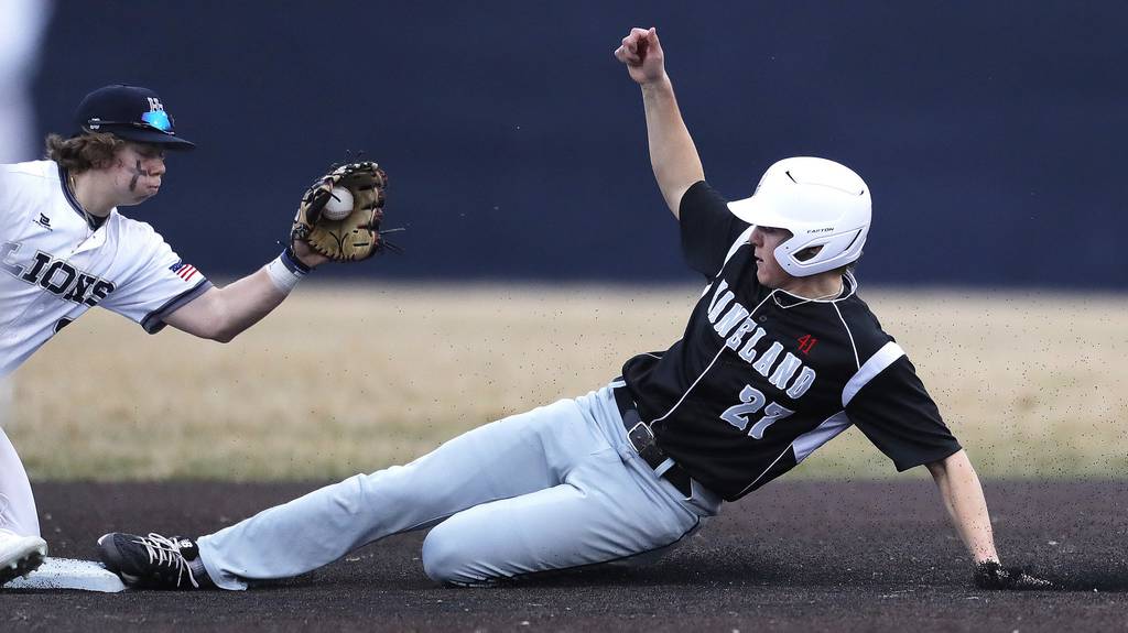 Kaneland's Gabe Gooch (27) slides under the tag of Harvest Christian's Gavin Duran (2) during a nonconference game at Judson's Hoffer Field on Monday, March 21, 2022