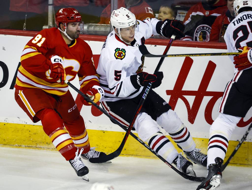 Blackhawks defenseman Connor Murphy, right, is checked by Flames forward Nazem Kadri during the second period on April 4 in Calgary, Alberta. 