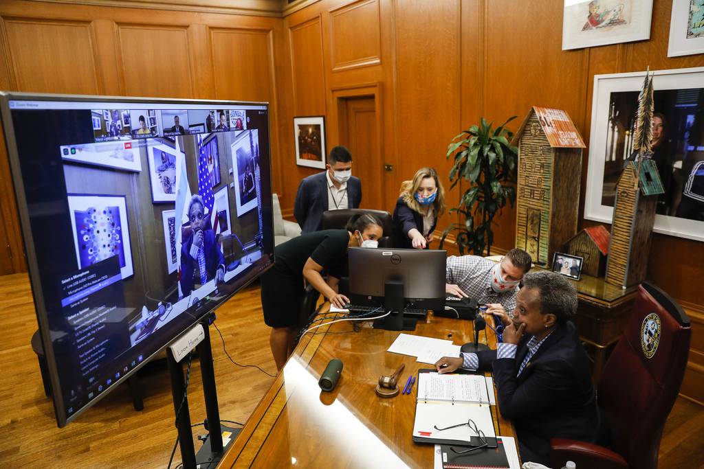 Mayor Lori Lightfoot's staff work on technical issues at the beginning of a virtual City Council meeting from her office at City Hall on June 17, 2020.